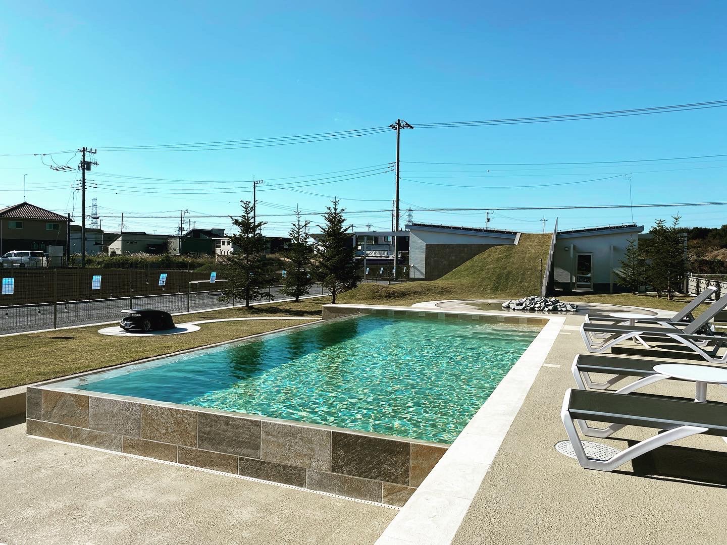 未来庭苑つくばの屋外プールとプールサイドのラウンジチェア